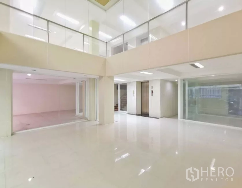 独立商业地产 出售在Bang Rak, Bangkok - 挑高大堂，玻璃隔间与夹层栏杆，电梯门及高光地面。