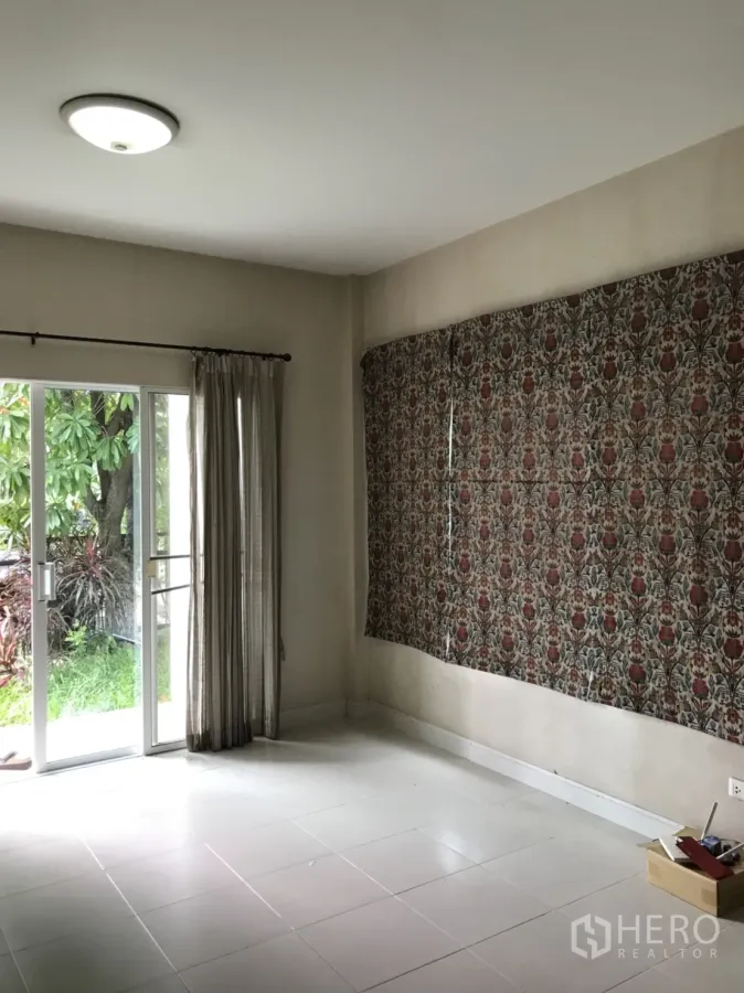 บ้าน ให้เช่าในLat Krabang, Bangkok - ห้องนั่งเล่นสว่าง พื้นกระเบื้องสีขาว ประตูกระจกบานเลื่อนและผ้าม่าน เปิดออกสู่สวนเขียวขจี