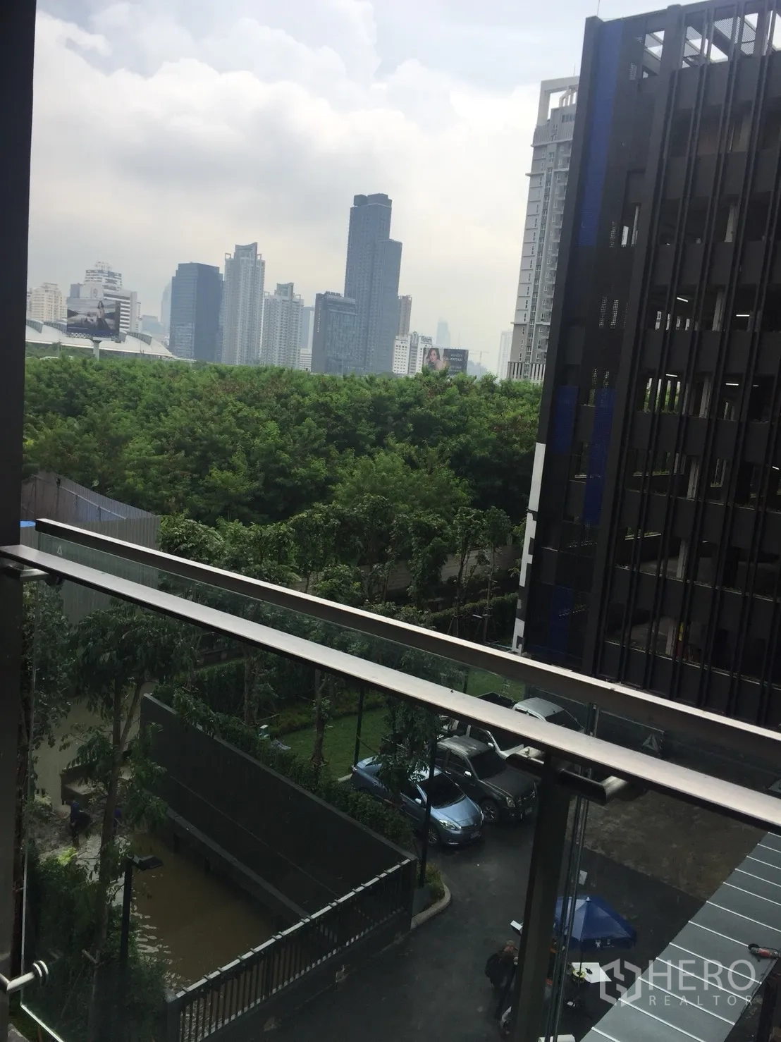 คอนโด ขายในDin Daeng, Bangkok - วิวระเบียงเห็นพื้นที่สีเขียว ลานจอดรถ และเส้นขอบฟ้าเมืองจากคอนโดย่านดินแดง