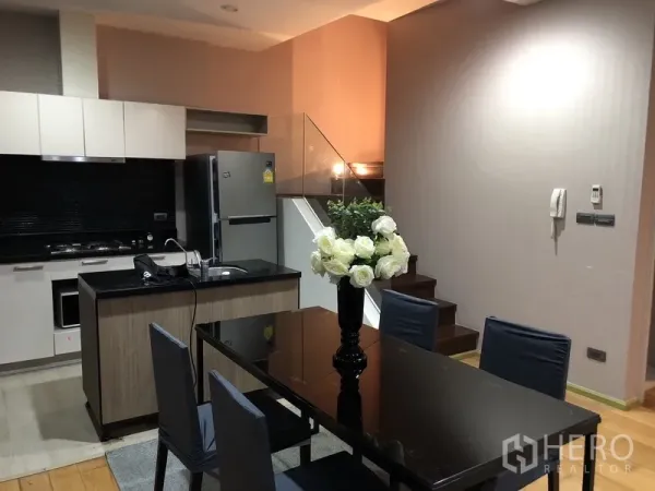 คอนโด ให้เช่าหรือขายในKhlong San, Bangkok - ครัวยุคใหม่ท็อปหินสีดำ ตู้ลอยสีขาว และโต๊ะอาหารติดกับบันไดราวกระจก