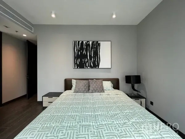 Condominium for rent in Bang Rak, Bangkok - Master bedroom with modern artwork, bedside tables and soft lighting.