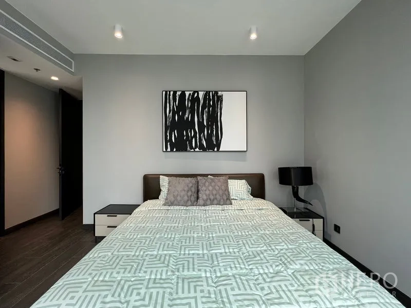 Condominium for rent in Bang Rak, Bangkok - Master bedroom with modern artwork, bedside tables and soft lighting.