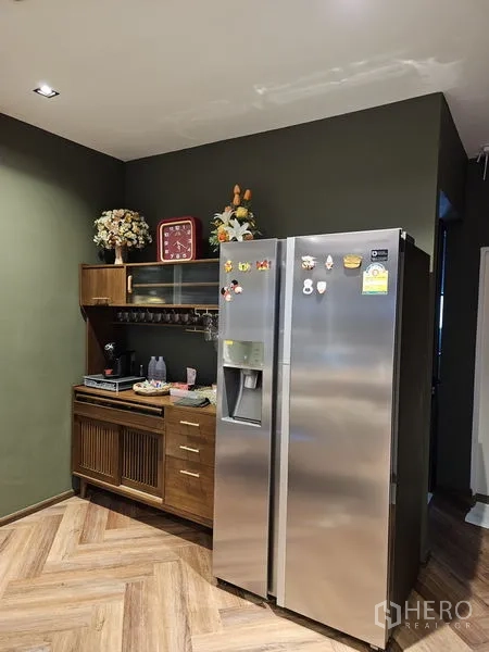 Detached House for sale in Thawi Watthana, Bangkok - Pantry area with green walls, stainless double-door fridge and wooden cabinet.