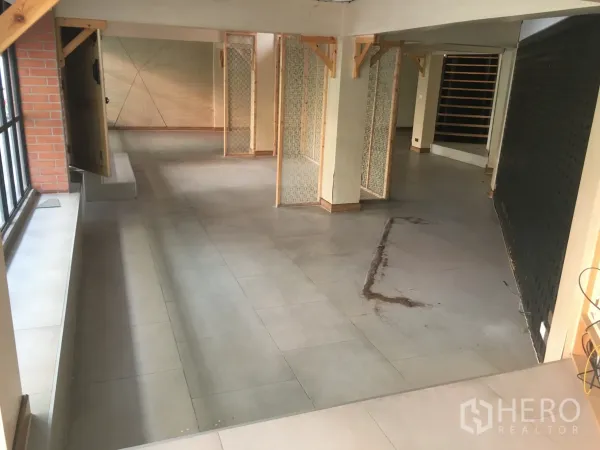 零售空间 出租在Khlong Toei, Bangkok - 一层展示空间，临街大窗与砖墙点缀，隔断灵活可调整动线。