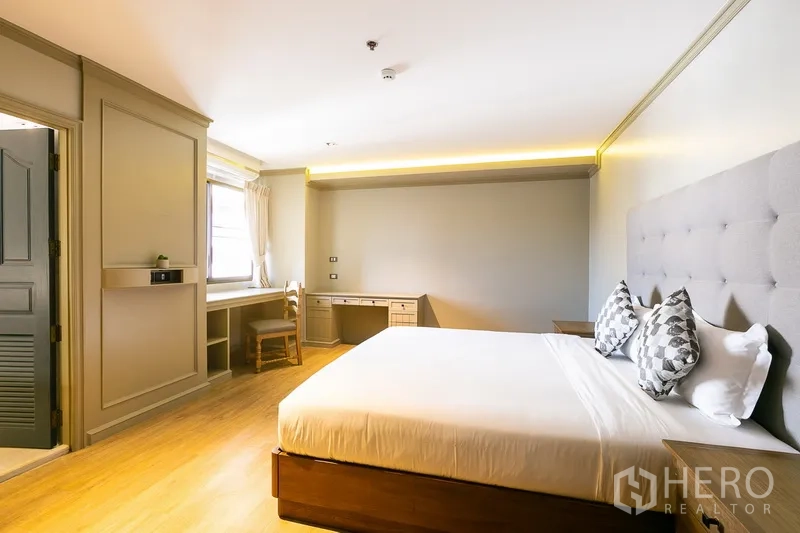 อพาร์ทเมนท์ ให้เช่าในKhlong Toei, Bangkok - ห้องนอนที่สองหัวเตียงบุผ้าและโต๊ะทำงานยาว