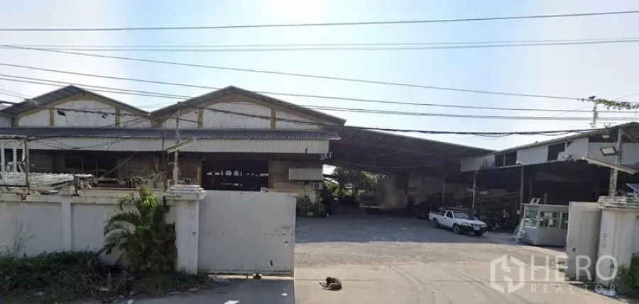 โรงงาน ให้เช่าในMueang Samut Prakan, Samut Prakan - มุมมองด้านหน้าโครงการคลังสินค้าอุตสาหกรรม พร้อมประตูรั้ว ทางรถเข้าออกกว้าง และหลังคาเมทัลชีทในสมุทรปราการ