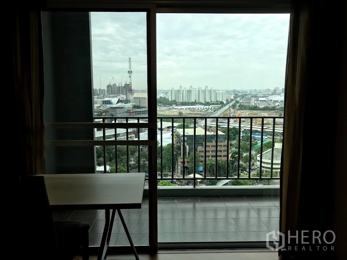 Condominium for rent in Huai Khwang, Bangkok - Sliding glass doors opening to a balcony with a panoramic Bangkok skyline view.