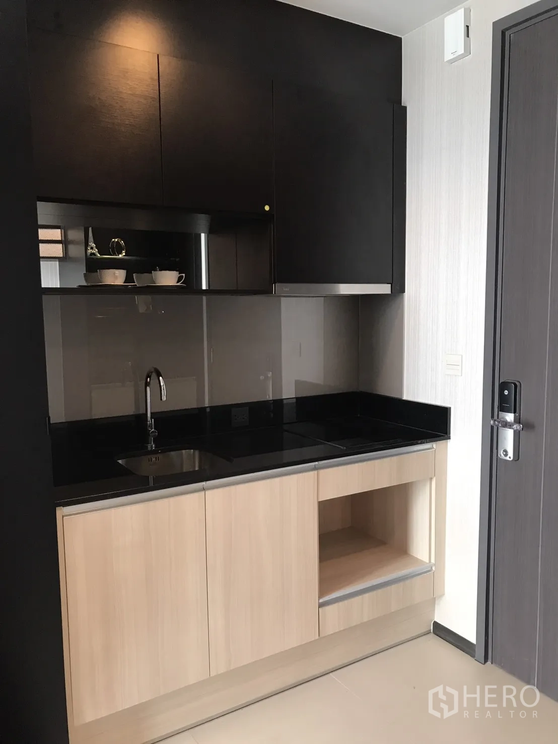 คอนโด ให้เช่าหรือขายในWatthana, Bangkok - ครัวขนาดกะทัดรัด ท็อปหินสีดำ เตาไฟฟ้า อ่างล้าง และตู้ไม้สีอ่อน