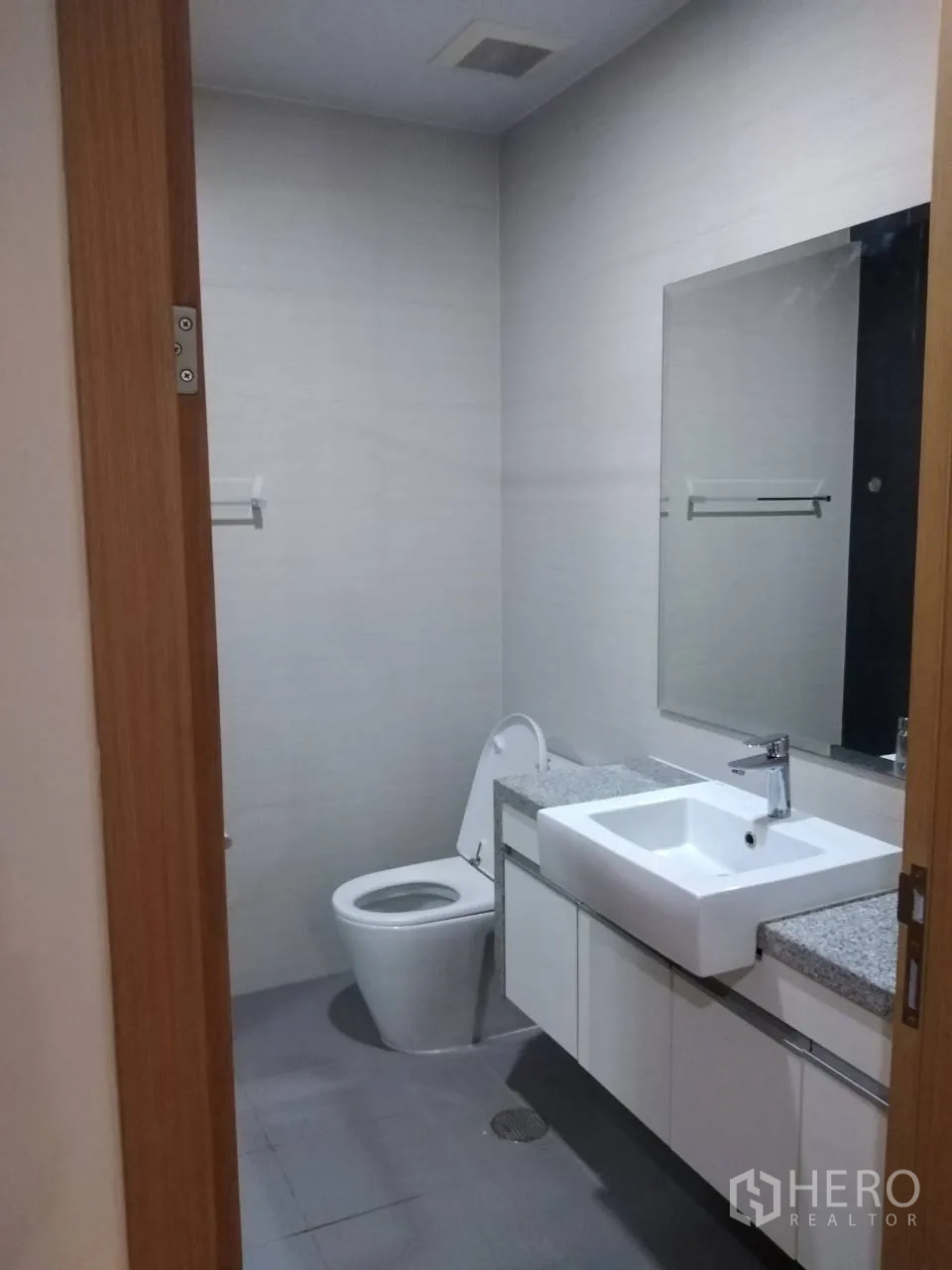 คอนโด ให้เช่าในKhlong Toei, Bangkok - ห้องน้ำสมัยใหม่พร้อมอ่างล้างหน้าเหลี่ยม ท็อปหิน กระจกบานใหญ่ และโถสุขภัณฑ์