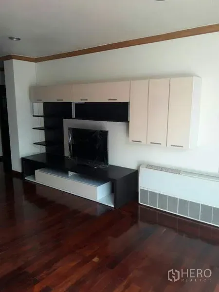 Condominium for rent in Pathum Wan, Bangkok - Modern media wall with cabinets and open shelving over rich hardwood flooring in the living area.