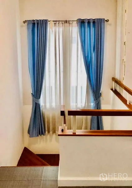 Detached House for rent or sale - Stairwell with wooden handrail and blue drapes over tall windows.