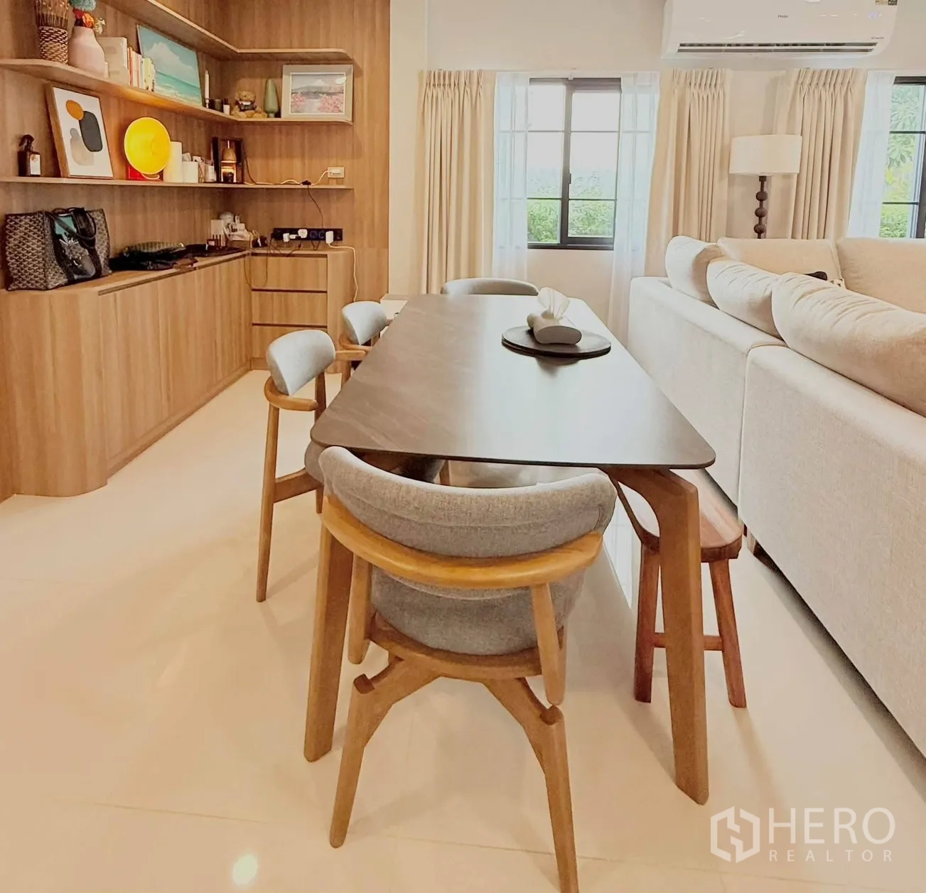 独栋房屋 for rent in Bang Phli, Samut Prakan - 餐厅配木质餐桌与软包餐椅，旁有展示层架与窗户。
