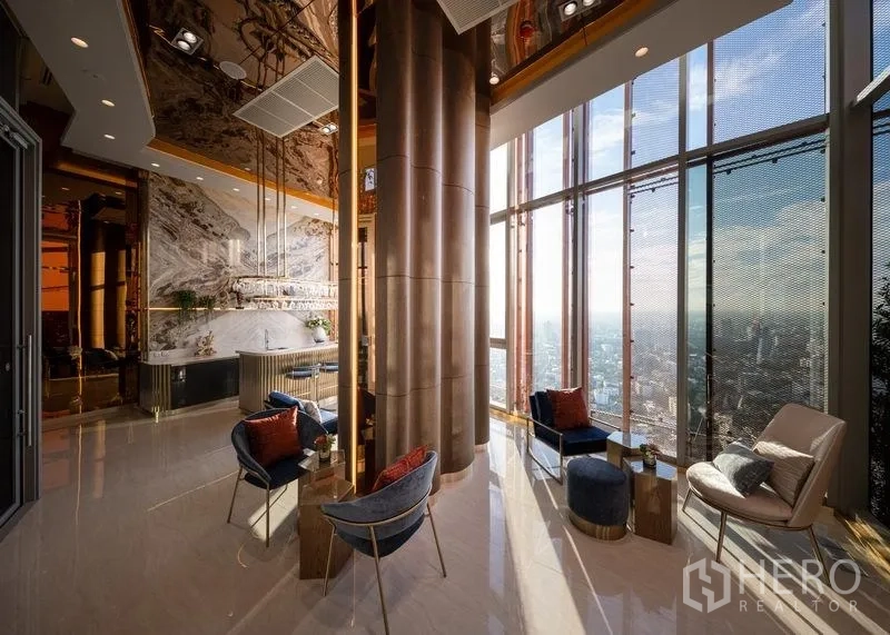 Condominium for sale in Chatuchak, Bangkok - Double-height sky lounge with floor-to-ceiling windows, plush seating, and expansive city panorama.