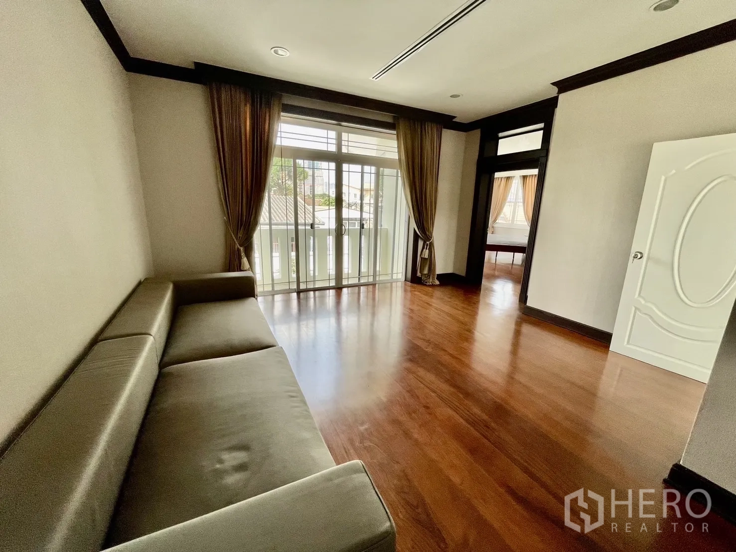 独立式住宅 出租在Chatuchak, Bangkok - 楼上家庭室，沙发与阳台门，木地板