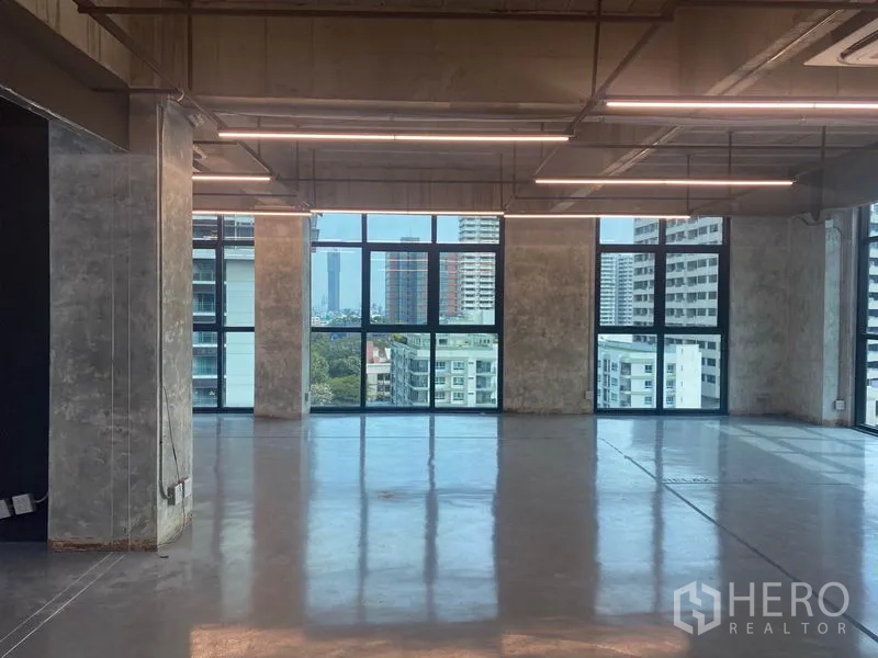 สำนักงาน ให้เช่าในKhlong Toei, Bangkok - พื้นที่สำนักงานแบบโอเพ่นเพลน เพดานเปลือย ไฟเส้นยาว LED และหน้าต่างบานใหญ่เห็นสกายไลน์กรุงเทพฯ.