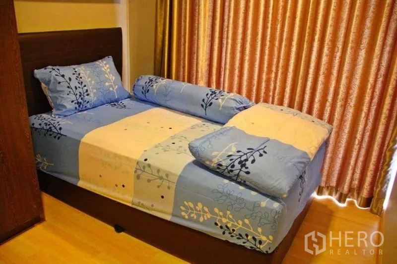 คอนโด ให้เช่าในPhaya Thai, Bangkok - ห้องนอนเล็กอบอุ่น เตียงผ้าปูสีน้ำเงิน ผ้าม่านสีทอง และพื้นไม้