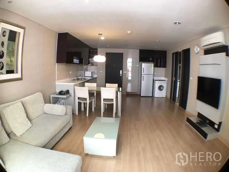 公寓 出租在Ratchathewi, Bangkok - 明亮客厅，配沙发、开放式厨房、餐桌、冰箱与洗衣机的现代公寓。