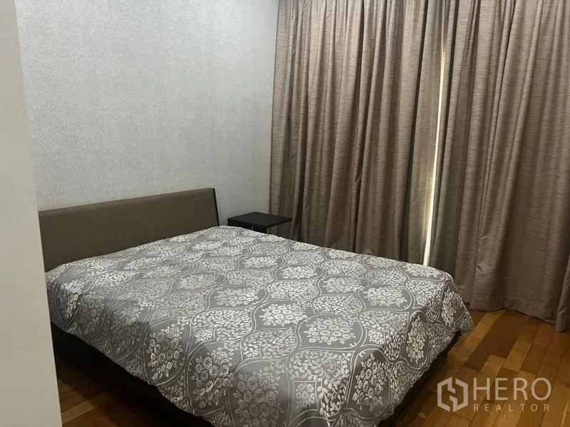 คอนโด ให้เช่าในBangkok - ห้องนั่งเล่นโซฟาหนังสีดำหันเข้าทีวี พร้อมผ้าม่านยาวและพื้นกระเบื้องเงา