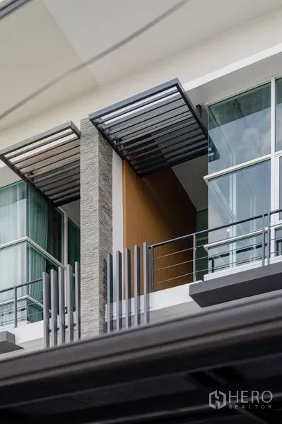 ทาวน์เฮาส์ ขายในLat Phrao, Bangkok - ระเบียงและกันสาดเหล็กของทาวน์เฮ้าส์สมัยใหม่ พร้อมผนังหินและกระจกบานใหญ่