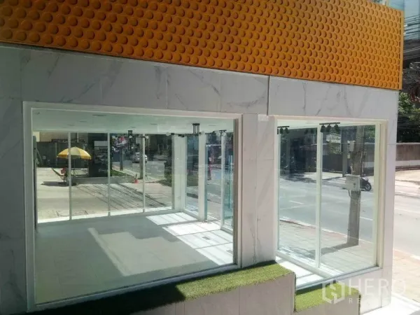 พื้นที่ขายปลีก ให้เช่าในKhlong Toei, Bangkok - หน้าร้านมุมติดถนน กระจกเต็มบานสองด้าน ผนังลายหินอ่อนพร้อมแผงสีเหลือง มองเห็นได้ชัดเจน