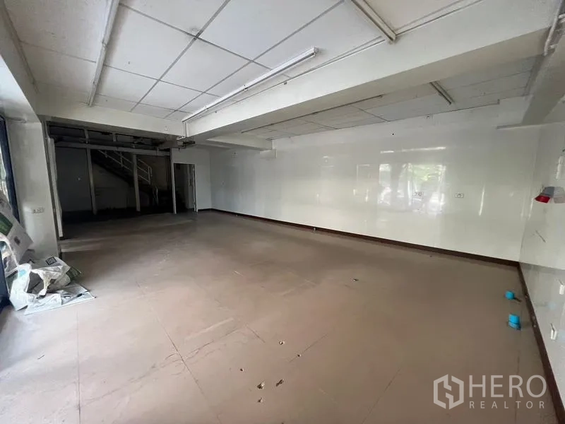 Shophouse for rent in Watthana, Bangkok - Ground-floor retail area with open plan layout, white walls and fluorescent lighting.