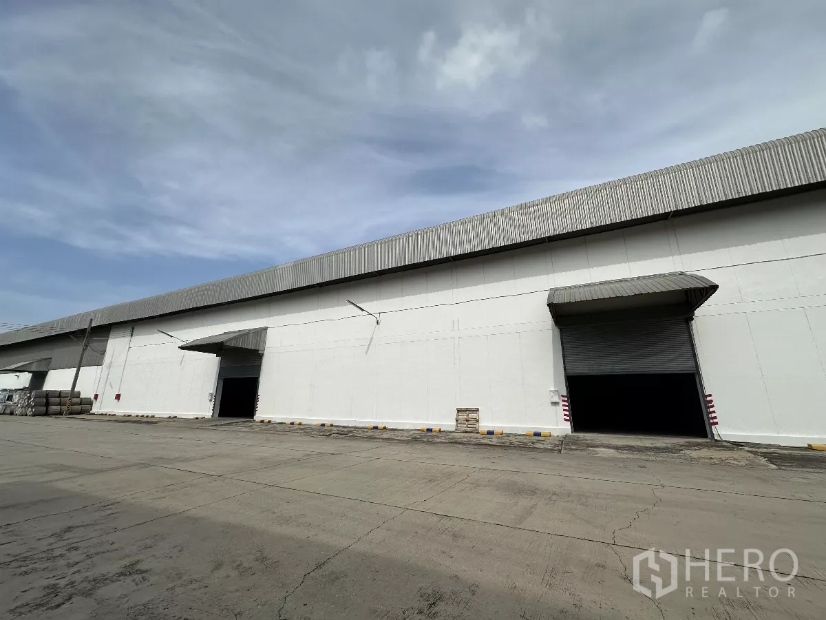 คลังสินค้า ให้เช่าในPhra Nakhon Si Ayutthaya - ด้านนอกอาคารโกดังยาว มีช่องโหลดหลายจุดพร้อมชายคา และลานรถบรรทุกกว้าง