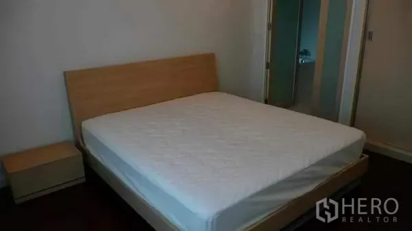 公寓 出租在Ratchathewi, Bangkok - 极简卧室，木质床架、床垫与床头柜。