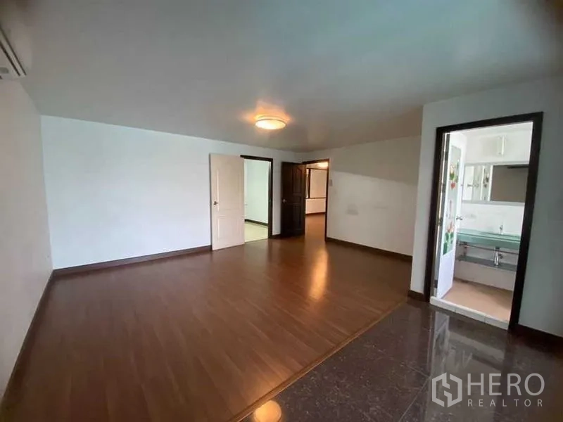 Home Office for rent in Don Mueang, Bangkok - Bedroom with en-suite entrance and wood flooring.