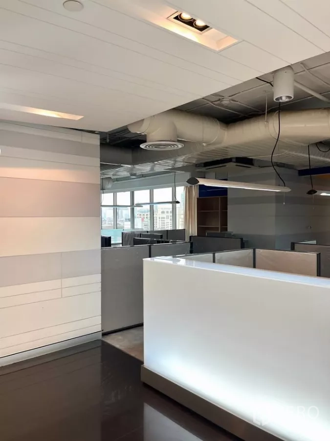 办公空间 出租在Khlong Toei, Bangkok - 设有接待台和隔间工位的现代办公室，大窗与外露风管。