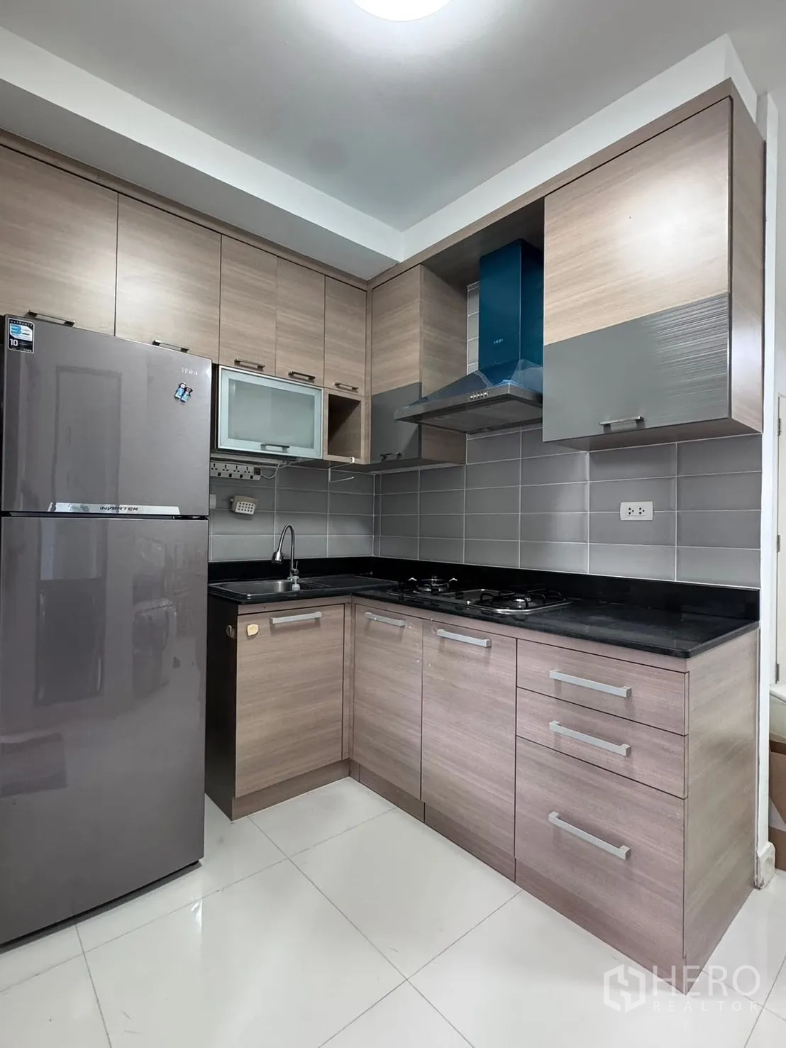 联排别墅 for rent in Phra Khanong, Bangkok - L形厨房配燃气灶、油烟机、冰箱和大量橱柜。