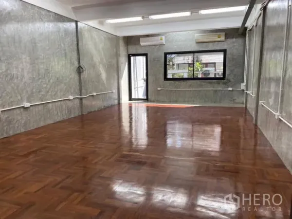 办公空间 出租在Yan Nawa, Bangkok - 采光良好的开放式办公室，拼花木地板，清水混凝土墙，大窗与分体空调。