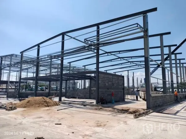 货栈 出租在Samut Prakan - 邦普里在建新仓库，钢结构高挑，砖砌墙体与宽阔混凝土场地。