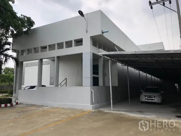 工厂 出租在Lat Krabang, Bangkok - 建筑转角处，带顶棚的停车区与卷闸门