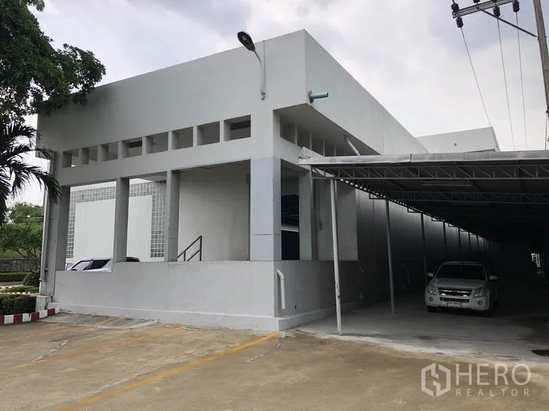 工厂 出租在Lat Krabang, Bangkok - 建筑转角处，带顶棚的停车区与卷闸门