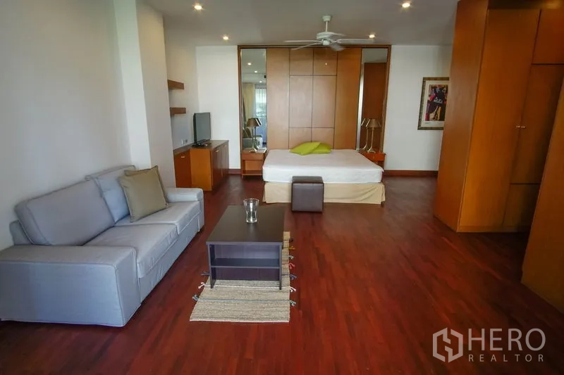 อพาร์ทเมนท์ ให้เช่าในWatthana, Bangkok - ห้องนอนมาสเตอร์ขนาดใหญ่ พื้นไม้ พัดลมเพดาน มุมนั่งเล่น ตู้เสื้อผ้าบิลท์อิน และชั้นวางทีวี