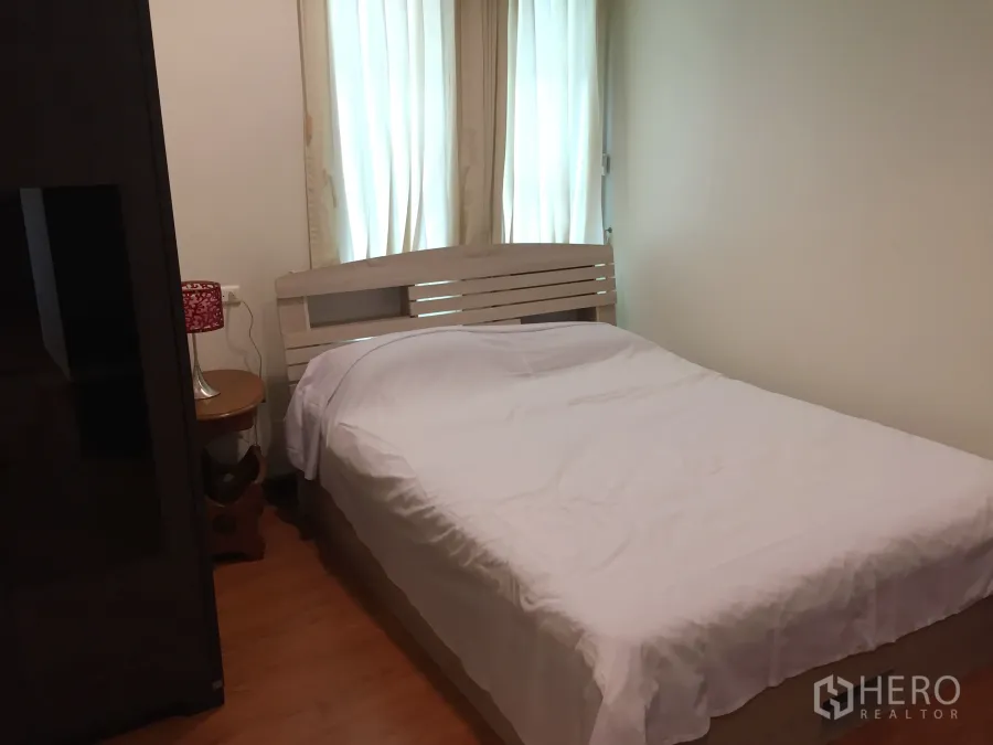 คอนโด ให้เช่าในKhlong Toei, Bangkok - ห้องนอนสว่าง พื้นไม้ ผ้าม่านสีอ่อน และเตียงปูผ้าขาว ในคอนโดสุขุมวิท