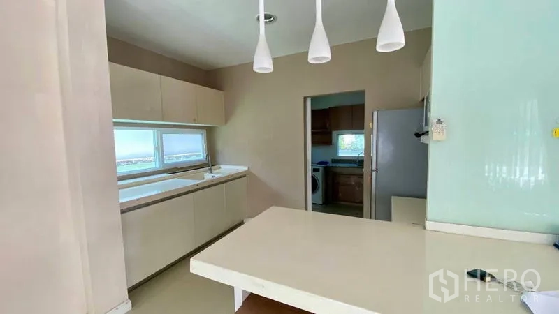 Detached House for rent in Bang Kapi, Bangkok - Pantry and breakfast bar with pendant lights leading to Thai kitchen.