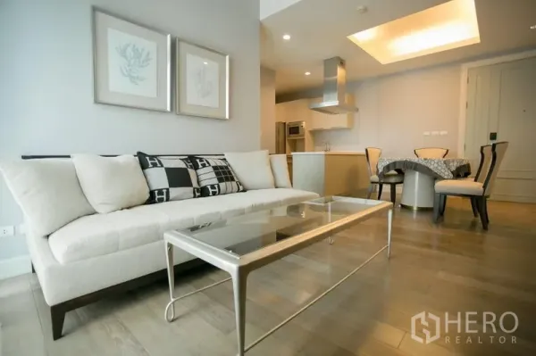 คอนโด ให้เช่าในPathum Wan, Bangkok - ห้องนั่งเล่นสว่าง เฟอร์นิเจอร์โทนครีม โต๊ะกลางกระจก พื้นไม้ ต่อเนื่องสู่ครัวและมุมทานอาหาร