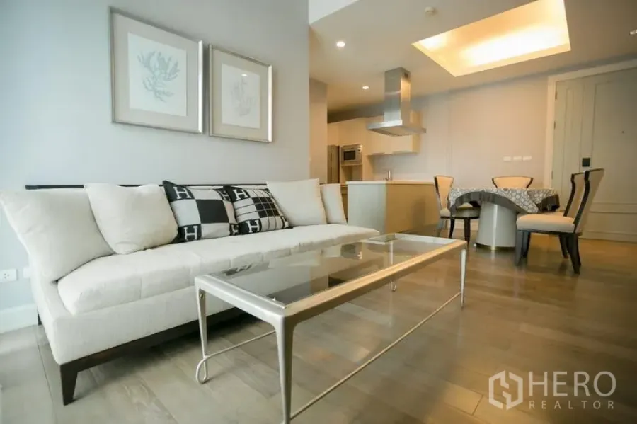 คอนโด ให้เช่าในPathum Wan, Bangkok - ห้องนั่งเล่นสว่าง เฟอร์นิเจอร์โทนครีม โต๊ะกลางกระจก พื้นไม้ ต่อเนื่องสู่ครัวและมุมทานอาหาร