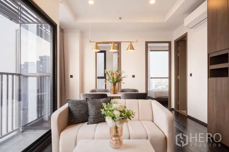 公寓 出租在Watthana, Bangkok - 开放式起居区，通向阳台并连接餐桌与吊灯照明