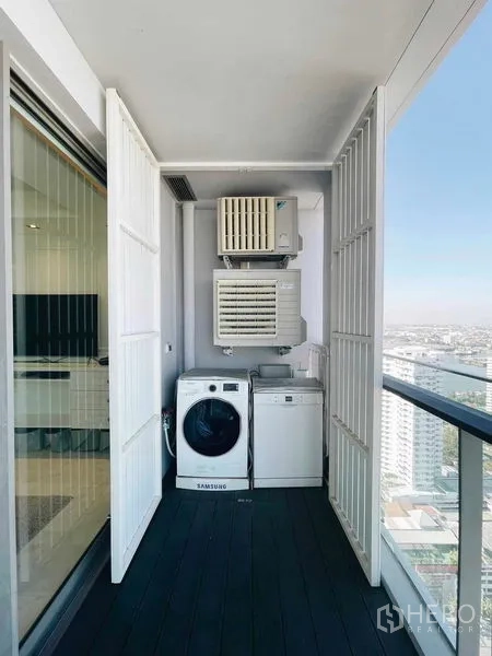 Condominium for rent or sale in Bang Kho Laem, Bangkok - Utility balcony with washer, dryer, and air-conditioning condensers neatly enclosed.