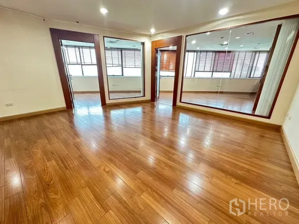 Office Space for rent - Bright open workspace with wooden flooring, glass-partitioned rooms and large windows with blinds.