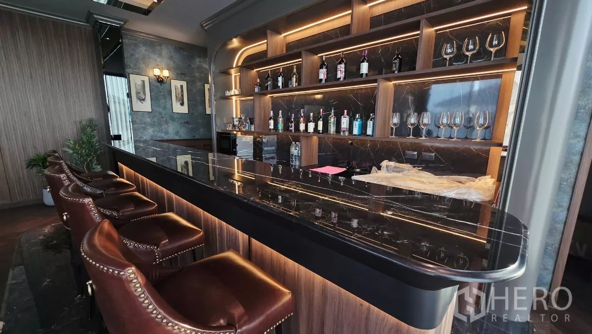 Detached House for rent in Prawet, Bangkok - Close-up of the stylish bar with backlit shelves and a dark marble counter.