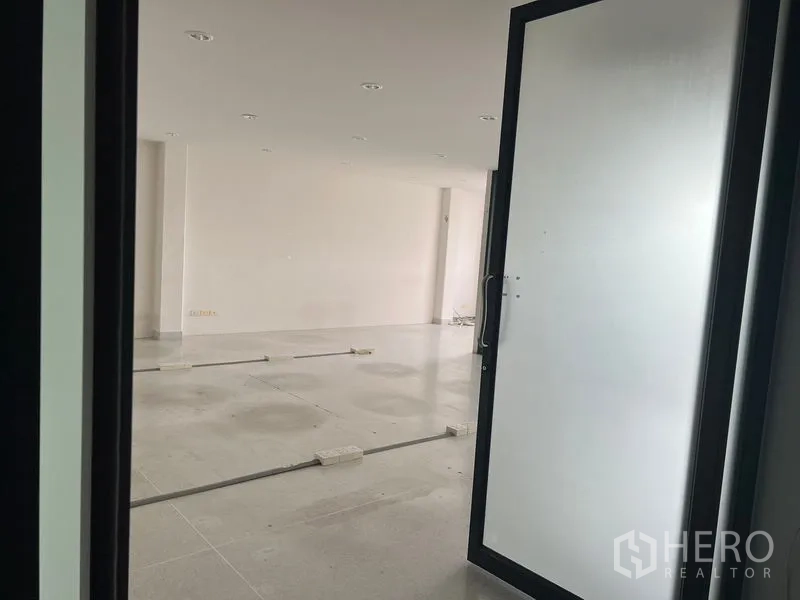 Office Space for rent in Mueang Samut Prakan, Samut Prakan - View through a frosted glass door into an unfinished open office floor with cable trunking.