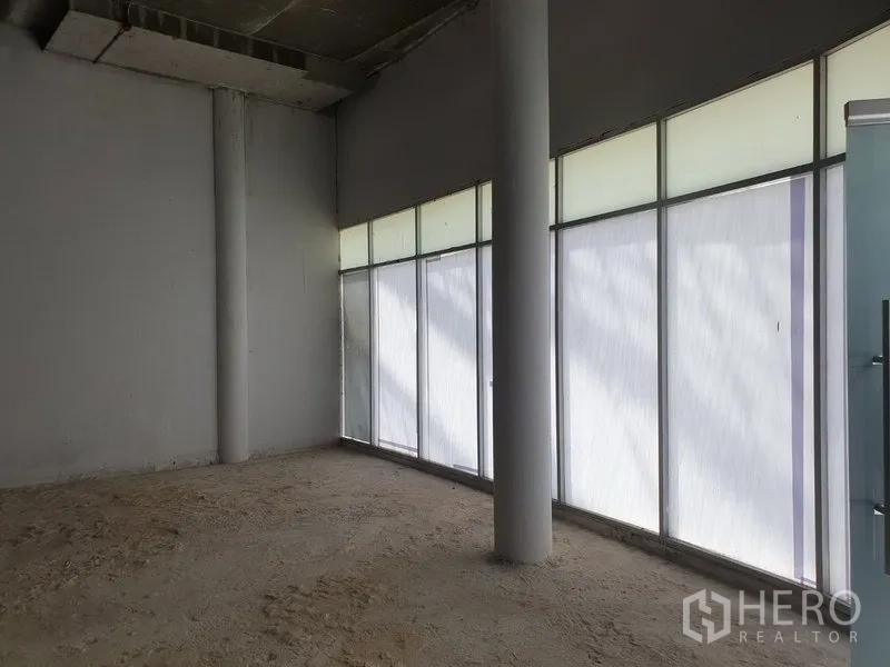 พื้นที่ขายปลีก ให้เช่าในKhlong Toei, Bangkok - ภายในห้องร้านค้าโล่ง มีกระจกฟรอสต์ฟูลฮাইটและเสาคอนกรีตรอการฟิตเอาต์