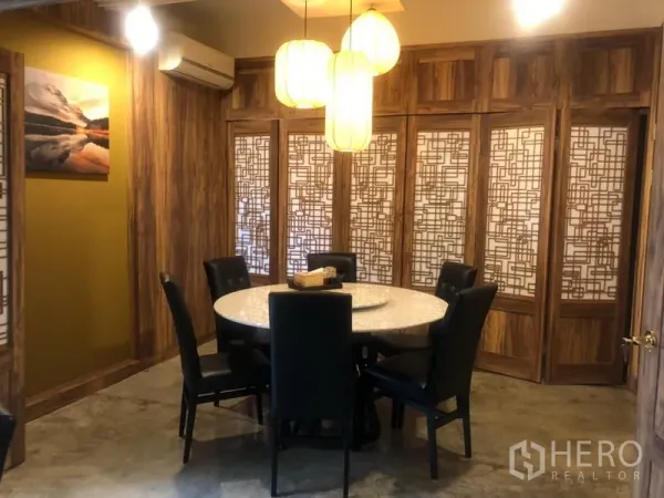 店屋 出租在Watthana, Bangkok - 温暖木质包间，几何花格屏风、圆桌与柔和吊灯。