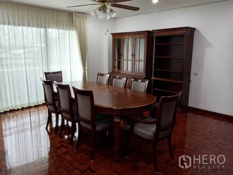 คอนโด ให้เช่าในWatthana, Bangkok - ห้องทานอาหารสว่าง โต๊ะไม้ 8 ที่นั่ง พัดลมเพดาน และผ้าม่านโปร่ง