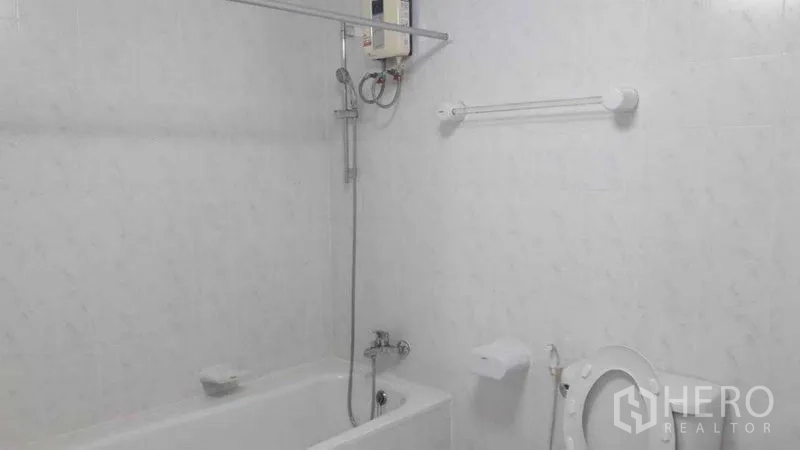 อพาร์ทเมนท์ ให้เช่าในPathum Wan, Bangkok - ห้องน้ำปูกระเบื้องสีขาว ฝักบัวเหนืออ่าง เครื่องทำน้ำอุ่น และโถสุขภัณฑ์