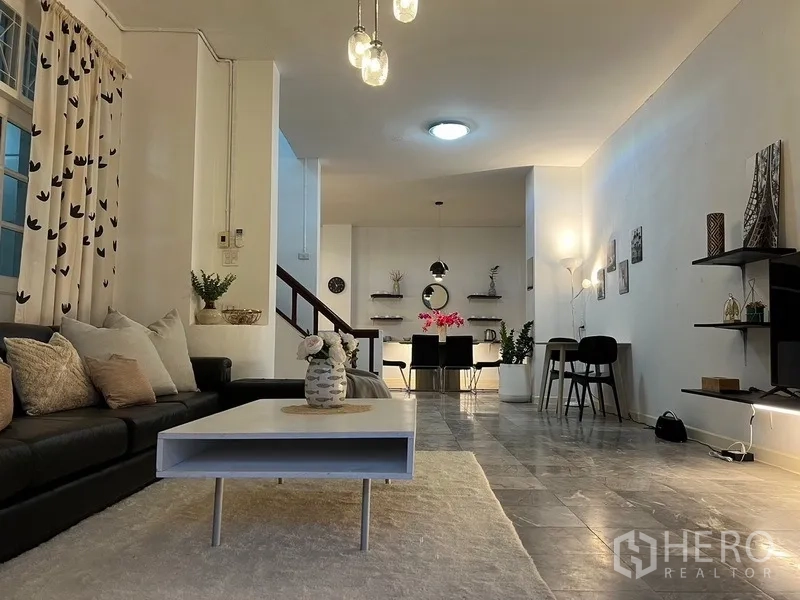 Home Office for rent in Suan Luang, Bangkok - Open-plan living and dining area with lounge, pendant lights and staircase.