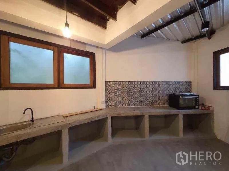 Detached House for rent in Pathum Wan, Bangkok - Minimalist kitchen with concrete counters, patterned backsplash and exposed ceiling